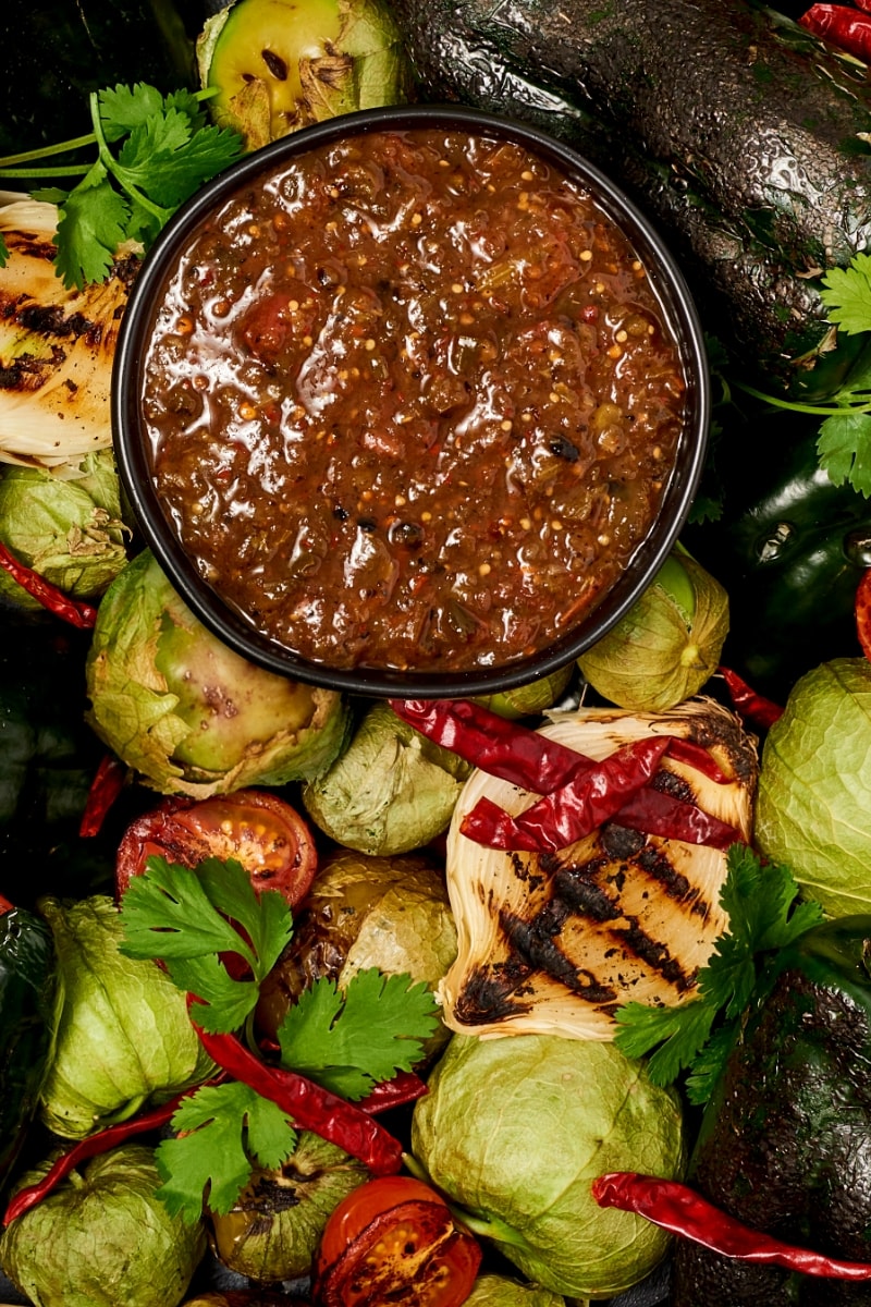 Salsa Poblano in a bowl on a bed of charred veggies