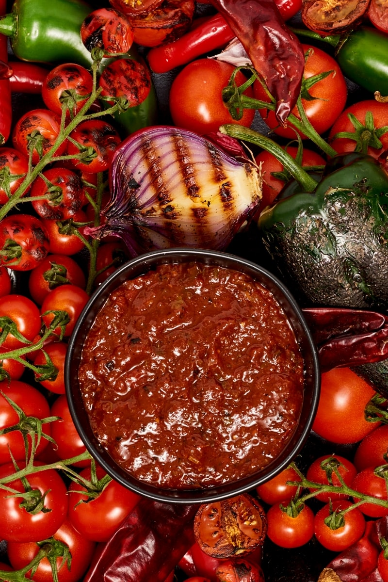 Salsa Roja in a bowl on top of charred veggies