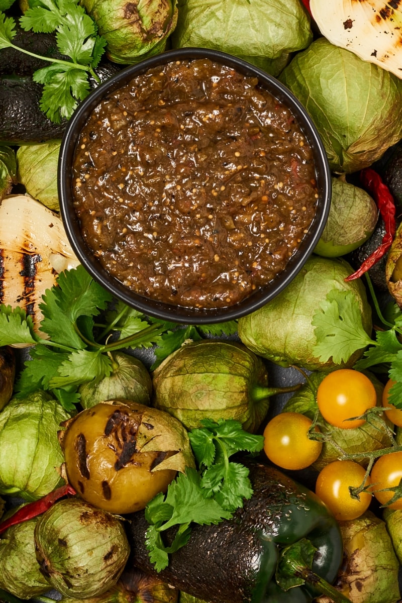 Salsa Verde in a bowl on a bed of charred veggies