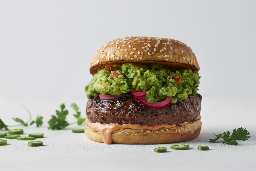 A burger topped with guacamole
