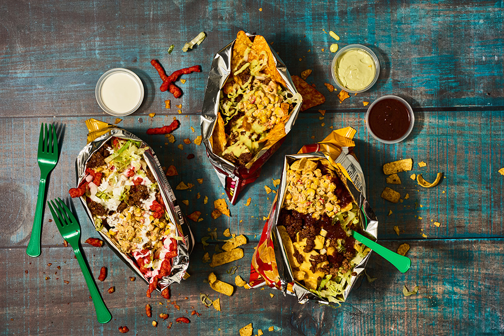 Three bags of tacos in a bag topped with street corn